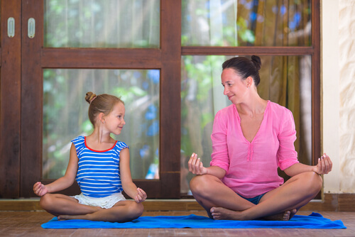 Madre enseñando a meditar a su hija