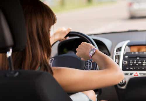 Mujer conduciendo con prisas conduciendo mirando el reloj