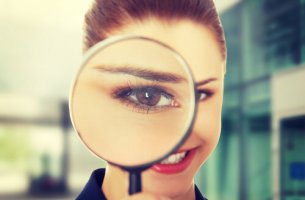 Mujer con una lupa sintiendo curiosidad