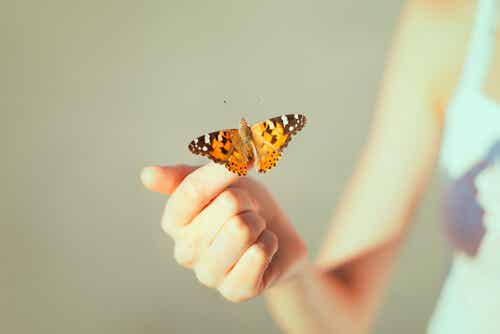 Mujer con una mariposa en su mano
