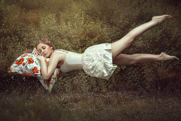 Mujer durmiendo apoyando la cabeza en un cojín de flores