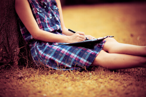 Mujer escribiendo sus objetivos en una libreta