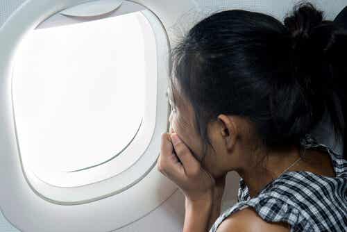 Mujer mirando por la ventanilla del avión con aerofobia