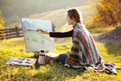 Woman painting an oil painting in the field