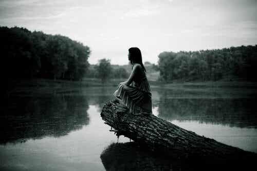 Mujer sentada sobre el río 