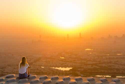 Eenzame vrouw die naar de zonsopgang kijkt