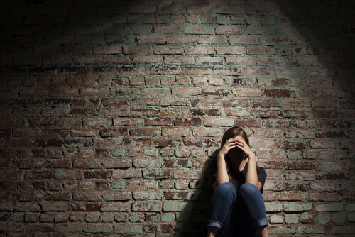 Mujer triste apoyada en la pared