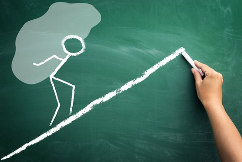 Muñeco subiendo una piedra por una montaña