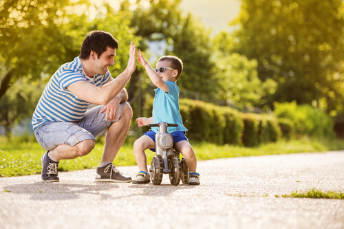 Niño chocando la mano con su padre