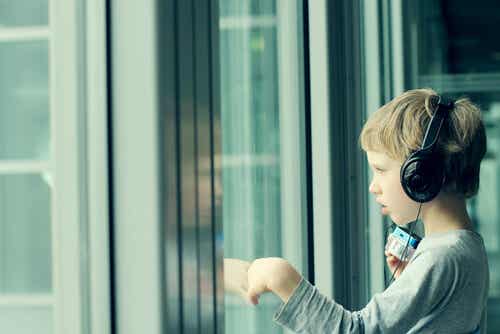 Niño con asperger escuchando música con sus auriculares