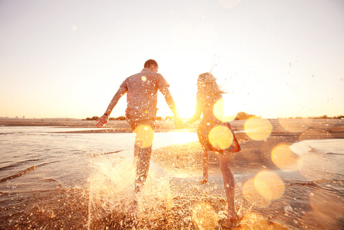 Pareja feliz corriendo por el mar