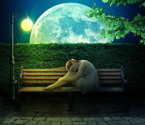 Persona introvertida en un banco a la luz de la luna