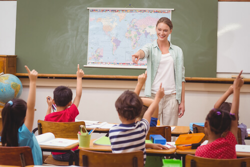 Profesora dando la palabra a niños en clase