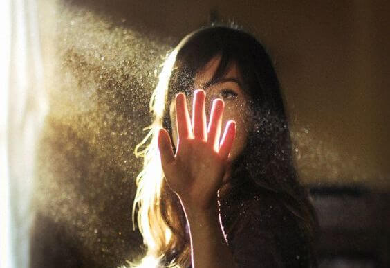 mujer con la mano en un haz de luz