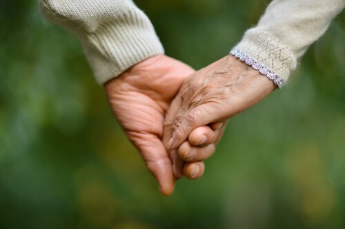 Pareja de ancianos de la mano