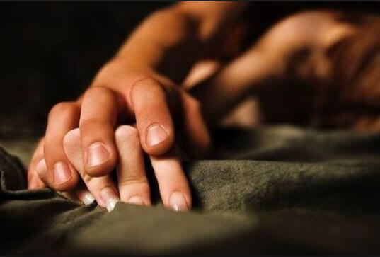 Manos entrelazadas de dos personas experimentando placer