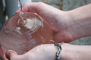 manos sosteniendo una fuente de agua