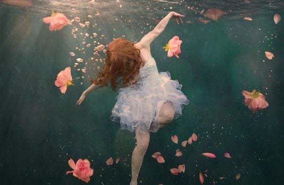chica bajo el agua con rosas