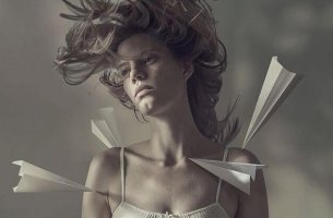 Mujer con aviones de papel en el cuerpo