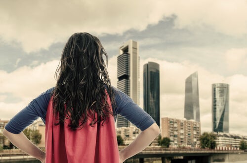Mujer con capa roja de superheroína pensando en héroes