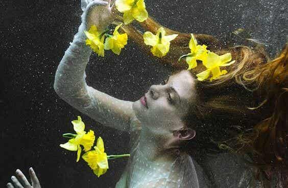 Pływająca pod wodą kobieta otoczona białymi liliami