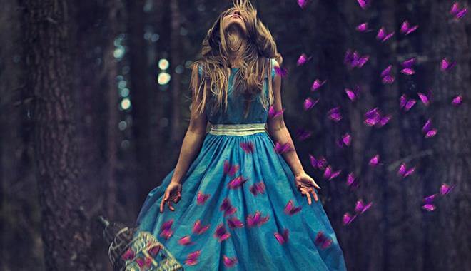 Mujer con vestido azul rodeada de mariposas