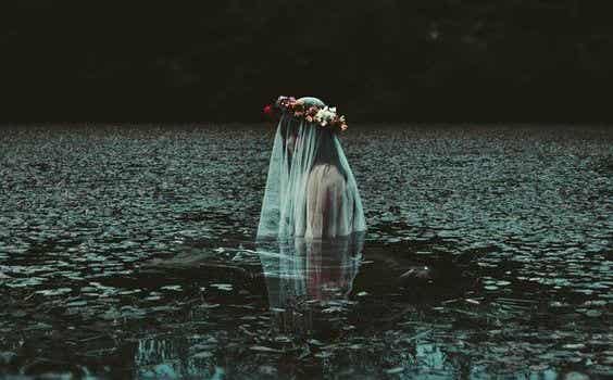 mujer con corona de flores en el agua