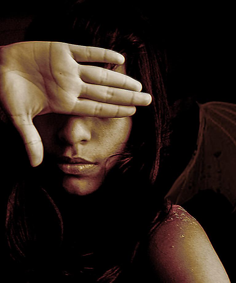 Mujer con mano tapándose los ojos