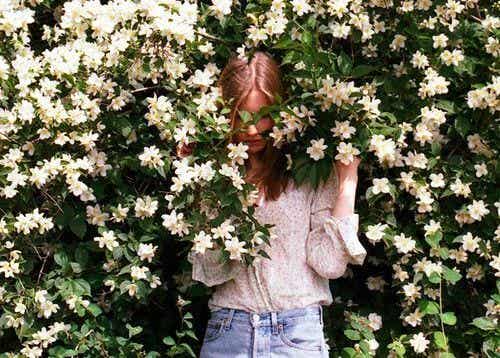 mujer en una enredadera de flores blancas