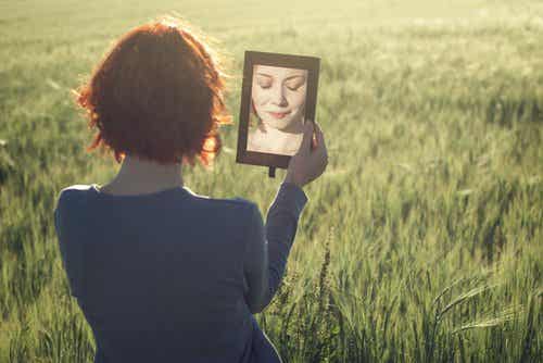 Mujer reflejada en un espejo entre la alegría y la tristeza