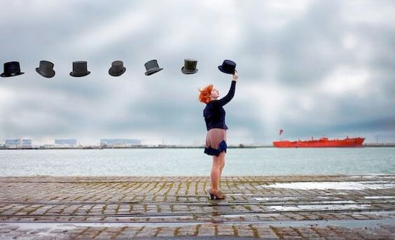 mujer sujetando una fila de sombreros flotantes