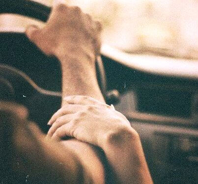 mujer tocando el brazo de un hombre mientras conduce