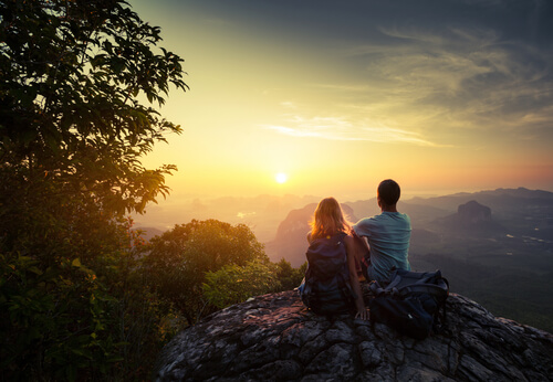 Amigos en la cima de la montaña observando el amanecer