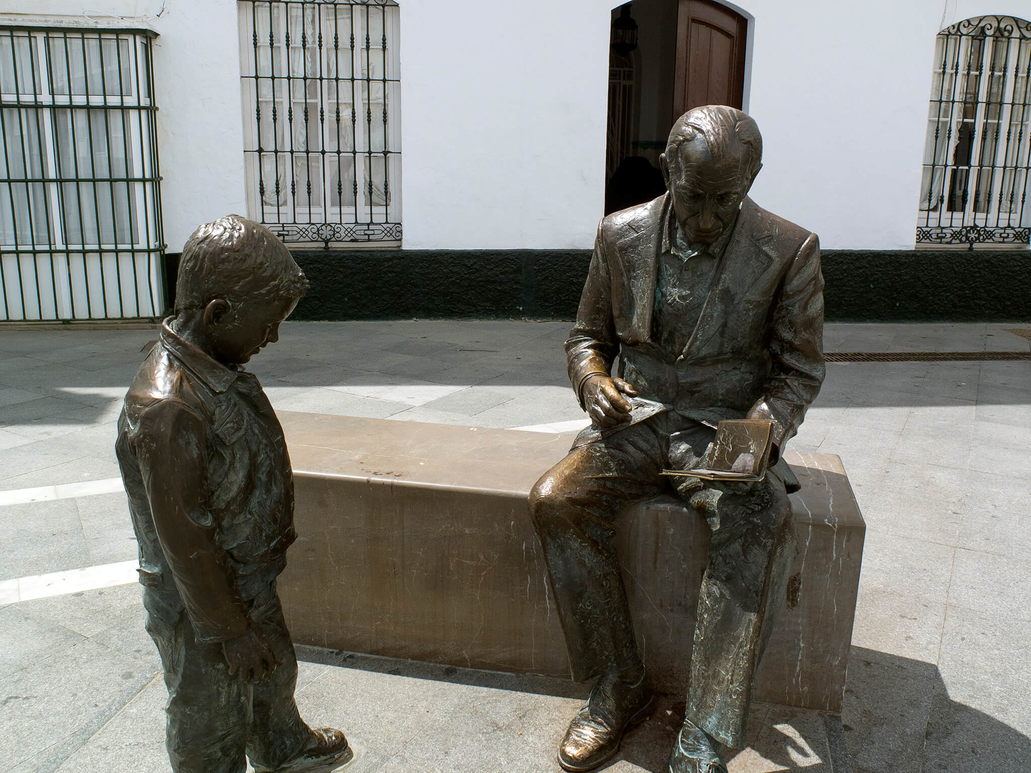 Estatura de José Saramago con un libro y un niño