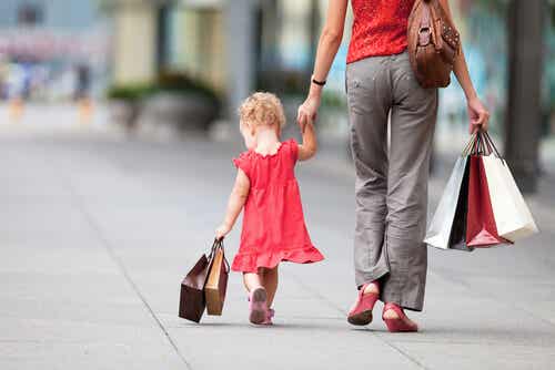 Madre e hija pequeña con bolsas de compras