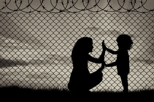 Madre e hija juntando las manos en un campo de refugiados