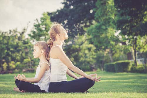 Madre e hija meditando dándose la espalda