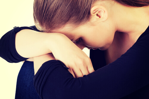 Mujer con la cabeza apoyada en las rodillas