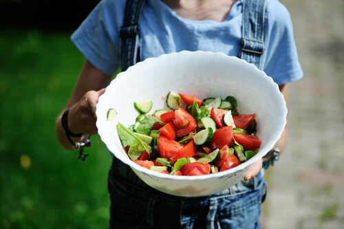 Niña con un plato de verduras