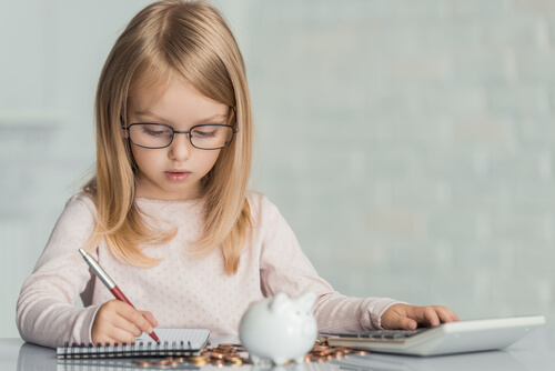Niña haciendo cuentas de su dinero en una libreta