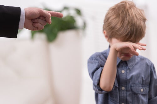 Niño llorando señalado por su padre con el dedo