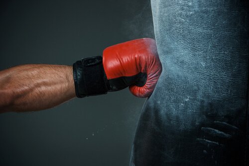 Brazo golpeando con rabia un saco de boxeo