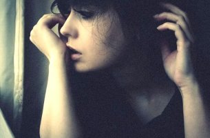 Chica mirando por la ventana con indiferencia