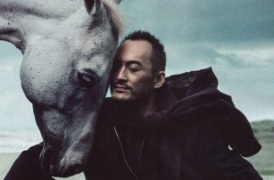 Hombre acariciando a un caballo para representar el equilibrio humano