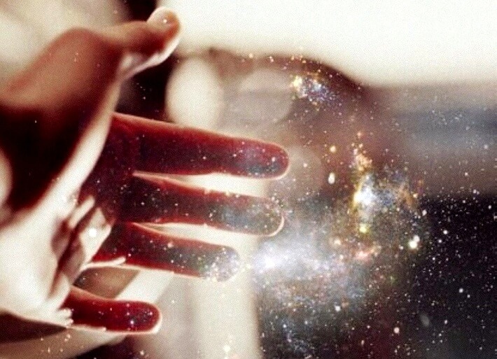 mano tocando un haz de energía