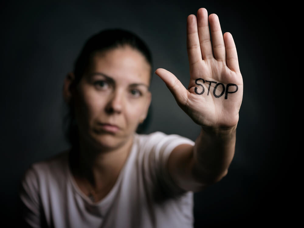 Mujer con la palabra stop escrita en la mano