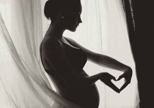 femme enceinte faisant un coeur