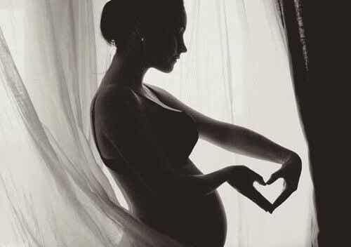 mujer embarazada haciendo un corazón