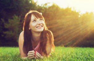 Mujer mirando hacia el sol representando optimismo