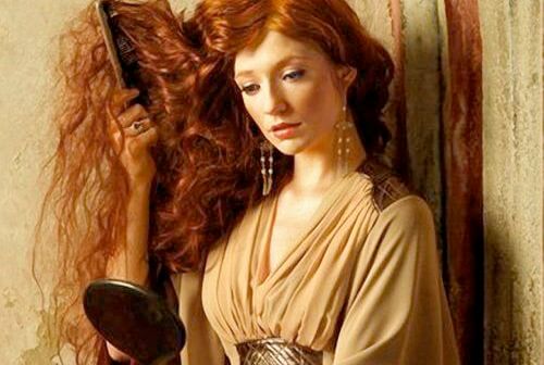 mujer pelirroja cepillándose el pelo